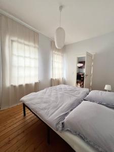 a white bedroom with a large bed and a window at Suite One - Haus Varel in Varel