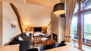 a living room with a couch and a fireplace at Résidence Les Terrasses D'eos - Appartement confortable · Accès direct aux pistes · Piscine · Spa · WIFI gratuit et illimité MAE-6164 in Magland