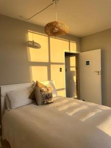 a bedroom with a white bed and a window at Charming beachfront Strand apartment in Cape Town