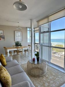 a living room with a couch and a table at Charming beachfront Strand apartment in Cape Town