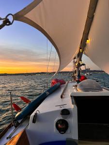 a boat in the water with a sunset in the background at Alpha - Boat House in Faro