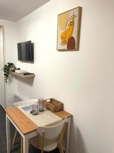 a room with a table and a picture on the wall at L’émeraude - T2 en plein coeur de Dinan in Dinan