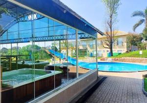 a building with a swimming pool and a building with windows at Maestro Thermas Park Hotel in Francisco Beltrão