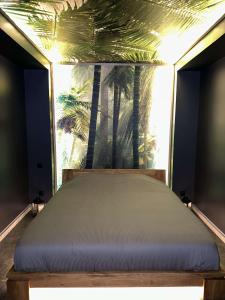 a bed in a room with palm trees in the background at Pool47spa in Précy-sur-Oise