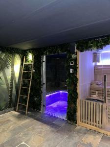 uma casa de banho com uma banheira roxa com plantas verdes em Pool47spa em Précy-sur-Oise