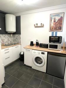 a kitchen with a washing machine and a microwave at L’émeraude - T2 en plein coeur de Dinan in Dinan
