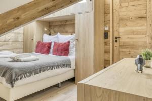 a bedroom with a large bed with red pillows at Résidence Gallery Mont Blanc - 3 Pièces pour 6 Personnes 634 in Saint-Gervais-les-Bains