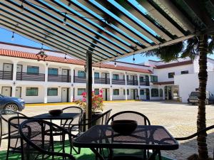 un patio avec des tables et des chaises et un bâtiment dans l'établissement HOTEL LOS PORTALES CHIGNAHUAPAN, à Chignahuapan