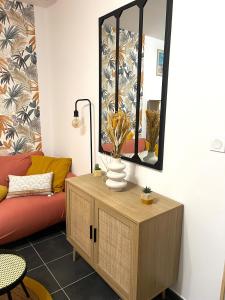 a living room with a red couch and a mirror at L’émeraude - T2 en plein coeur de Dinan in Dinan +3 photos