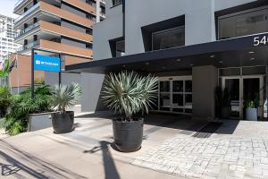 a building with three potted plants in front of it at Paulista Premium Flat in São Paulo