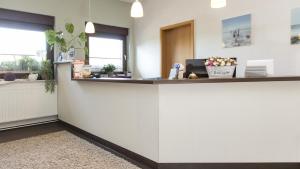 an office with a reception counter with flowers on it at Deichhotel Grube in Dorum Neufeld