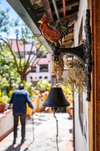 a bell with a rooster on the side of a building at Hostal Riviera Sucre in Otavalo