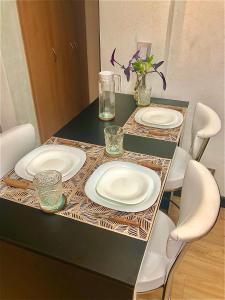 uma mesa com dois pratos brancos em cima em Alquiler por dia "Como en Casa" Caseros, cerca de Palomar y Hurlingham em Caseros