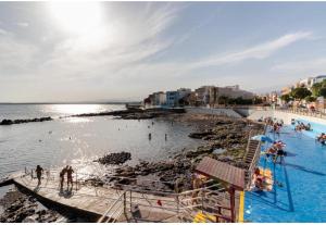 people swimming in the water at a beach at Rincón Mirador Risco Verde in Arinaga