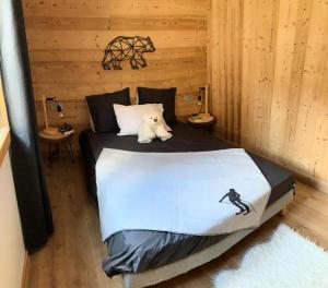 a white dog laying on a bed in a room at Chalet "cÔmo-brunate" - Chalets pour 8 Personnes 124 in Valloire