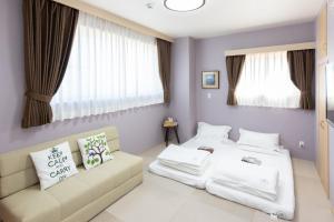 a bedroom with two beds and a couch at Light Hotel - Vacation STAY 91078v in Tokyo