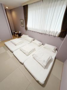 a group of white beds in a room with a window at Light Hotel - Vacation STAY 91078v in Tokyo