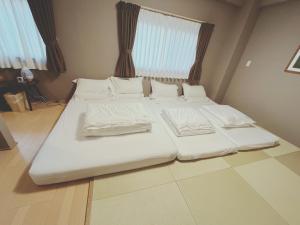 1 cama con sábanas blancas y almohadas en una habitación en Light Hotel - Vacation STAY 91078v en Tokio