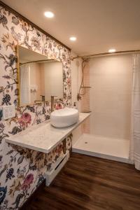 y baño con lavabo, espejo y bañera. en The Cove Guest House, en Prescott