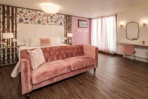 1 dormitorio con sofá frente a la cama en The Cove Guest House, en Prescott