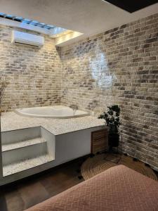 a bathroom with a tub and a brick wall at Peñiscola - Casa Mirador mit Gemeinschaftspool in Castellón de la Plana