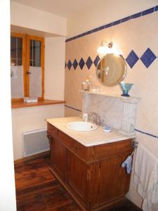 uma casa de banho com um lavatório e um espelho em Grande maison familiale en Ubaye em Faucon-de-Barcelonnette