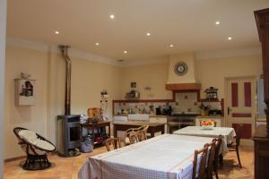uma grande cozinha com duas mesas e um fogão em Grande maison familiale en Ubaye em Faucon-de-Barcelonnette