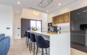 a kitchen with a counter and bar stools at 3 Bedroom Amazing Home In Torre Pacheco in Torre-Pacheco