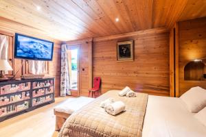 ein Schlafzimmer mit einem Bett in einem Holzzimmer in der Unterkunft Chalet As De Coeur - Chalets pour 14 Personnes 224 in Morzine