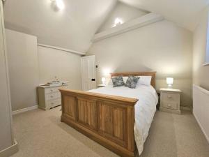1 dormitorio con 1 cama grande y 2 mesitas de noche en The Old Stables - Self Contained Cottage - Hot Tub and Pool en Salisbury