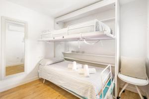 a small bedroom with a bunk bed and a chair at Apartamento Binibeca Vell in Binibeca