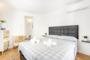 een slaapkamer met een groot bed met twee kaarsen erop bij Apartamento Binibeca Vell in Binibeca