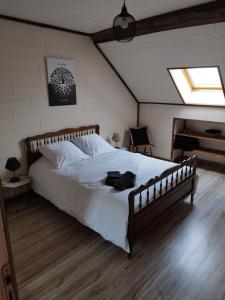 ein Schlafzimmer mit einem großen Bett und einem Klavier in der Unterkunft La Grange Aux Fleurs in Rigny-la-Nonneuse