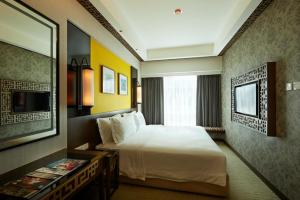 a hotel room with a bed and a television at Estadia Hotel in Malacca