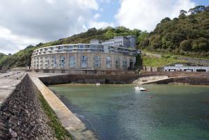 a large building with a boat in a body of water at Red Peg in Kingsand
