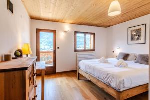 - une chambre avec un grand lit et un plafond en bois dans l'établissement Chalet L'ourson Blanc Morzine - 3 Pièces pour 6 Personnes 514, à Morzine