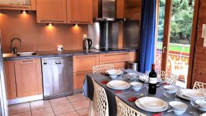 eine Küche mit einem Tisch mit Tellern und Weinflaschen in der Unterkunft Chalet Avoreaz - 3 Pièces pour 6 Personnes 554 in Morzine