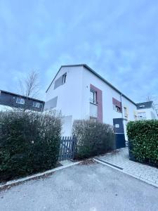 ein weißes Haus mit einem Zaun davor in der Unterkunft Großes & Modernes Ferienhaus 2 Minuten von Meersburg Innenstadt in Meersburg