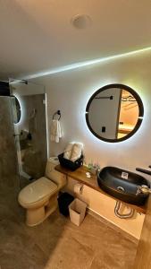 a bathroom with a sink and a toilet and a mirror at Avalon Hotel Campestre in Jardin
