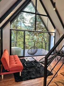 een woonkamer met een oranje bank en een groot raam bij Avalon Hotel Campestre in Jardin
