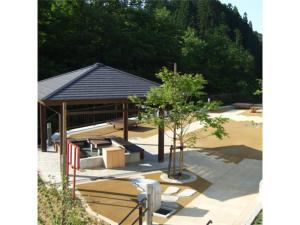 um pavilhão com bancos e uma árvore num parque em Oshuku Onsen Hotel Uguisu - Vacation STAY 27299v em Shizukuishi