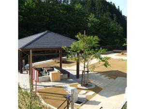 a pavilion with benches and a tree in a park at Oshuku Onsen Hotel Uguisu - Vacation STAY 27299v in Shizukuishi