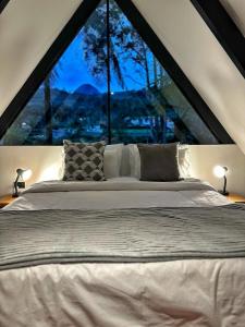a bed in a room with a large window at Avalon Hotel Campestre in Jardin