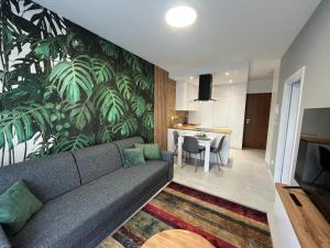ein Wohnzimmer mit einem Sofa und einem Esszimmer in der Unterkunft Apartament Zacisze 13 in Piaseczno