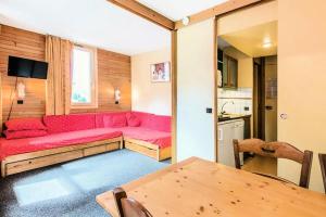 La Plagne Tarentaise的住宿－Résidence Les Chalets des Arolles - maeva Home - Studio 5 Personnes - Budget 34，客厅配有红色的沙发和桌子