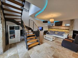 a living room with a spiral staircase in a house at Maison familiale au cœur du D-DAY in Vaux-sur-Aure