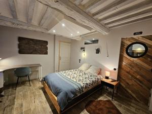 a bedroom with a bed and a desk and a chair at Maison familiale au cœur du D-DAY in Vaux-sur-Aure