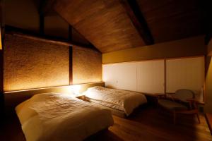 a bedroom with two beds and a desk and a chair at sou's minka Luru - Vacation STAY 62536v in Minamiechizen