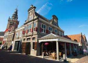 un bâtiment avec une tour d'horloge dans une rue dans l'établissement Waterland Achterhuis, à Monnickendam