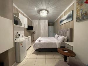 Un dormitorio con una cama y una mesa. en DOMIN LUXURY SUITES en Ciudad del Cabo